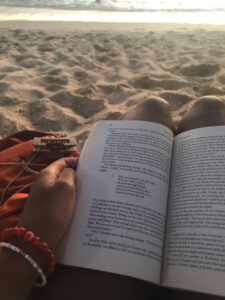 PERSON READING A BOOK AT THE BEACH